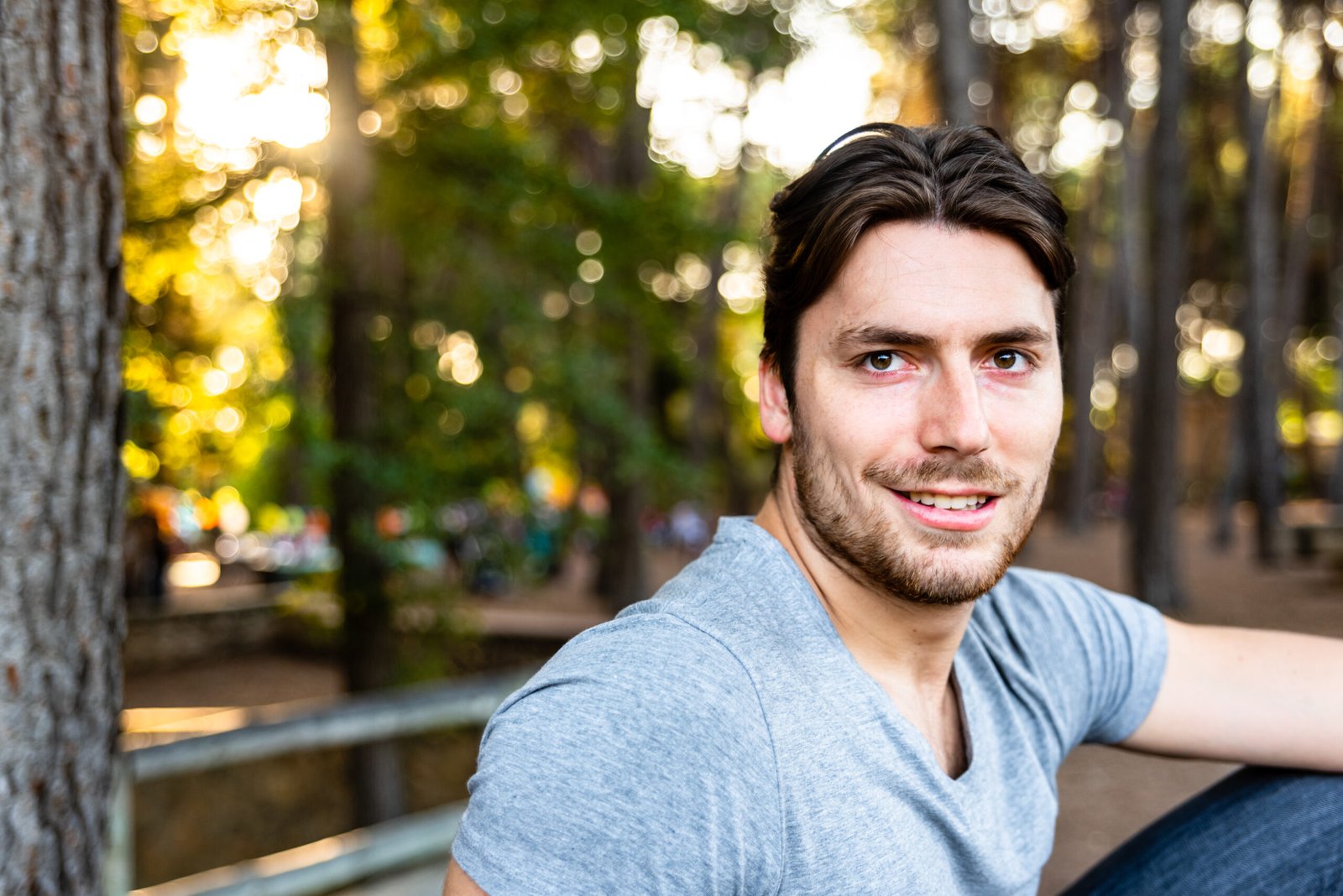 Close-up of a handsome young man model looks straight in front of the camera on a sunset